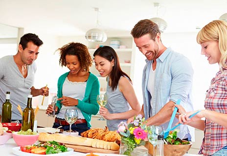 Eine Gruppe junger fröhlicher Menschen kocht zusammen.